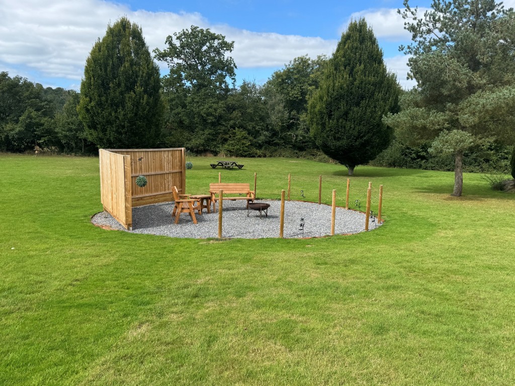 Lot: 71 - FREEHOLD TEN ACRE SITE WITH LAKES AND LODGES - Seating area in front of Damsel Lodge